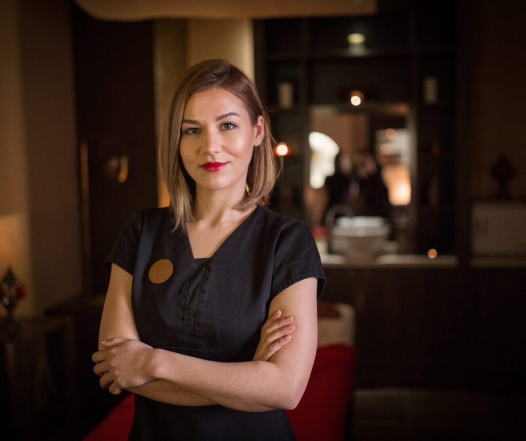 Beauty Therapist in dark tunic in a reception area